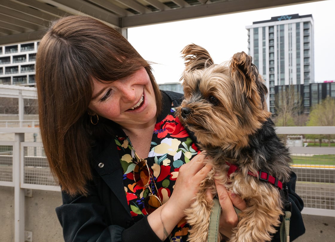 Henry, an impossibly small brown and black Yorkshire Terrier, is held up to the camera by his doting owner Leah